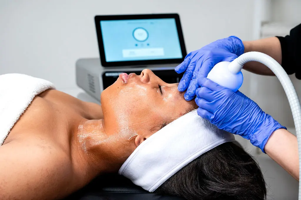 A Neveskin facial treatment being applied with a handheld wand